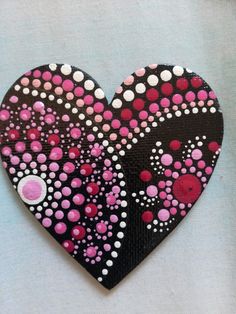 a black and pink heart with dots on it