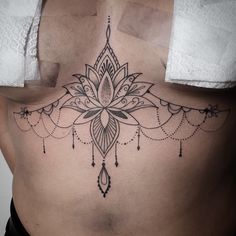 a woman's lower back with a tattoo design on her stomach and an intricate flower in the center