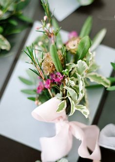 flowers and greenery are arranged on the table