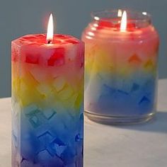 two colorful candles sitting next to each other on a table