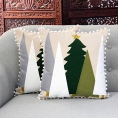 two christmas trees are on the back of a couch