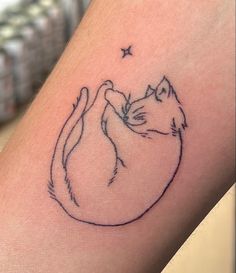 a small tattoo on the leg of a person with a cat and star in the background