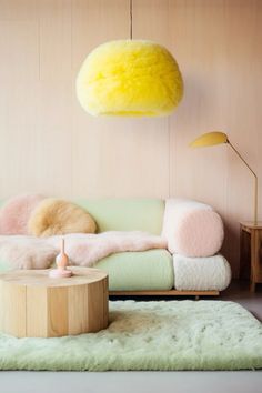 a living room filled with furniture and a yellow light hanging over the top of it