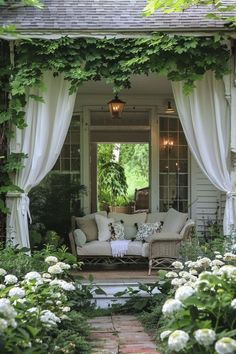 an outdoor living area with white flowers and greenery