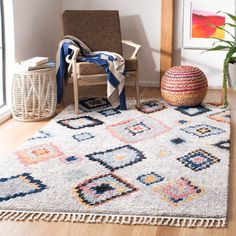 a living room area with a chair, rug and potted plant