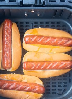 four hot dogs in buns with cheese on them and the words, the fastest air fryer hot dogs