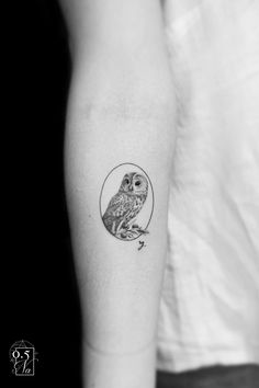 an owl tattoo on the left inner forearm and upper arm is shown in black and white