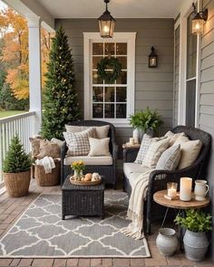 an outdoor porch with wicker furniture and potted plants on the front porch area