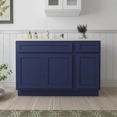 a blue bathroom vanity with two sinks and cupboards on the wall next to it