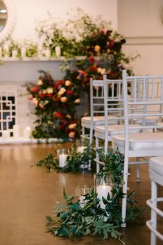 the aisle is decorated with greenery and candles