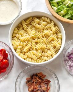 the ingredients for this pasta salad are neatly arranged in bowls