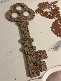 an old wooden key with keys all over it on a white table next to a mirror