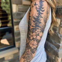 a woman's arm with flowers and birds on it