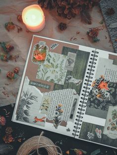 an open book sitting on top of a table next to a candle