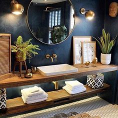 a bathroom with a sink, mirror and plants on the counter top in front of it