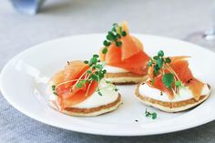 small appetizers with smoked salmon and cream cheese are served on a white plate