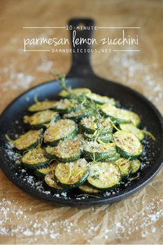 a skillet filled with sliced zucchini and parmesan cheese on top