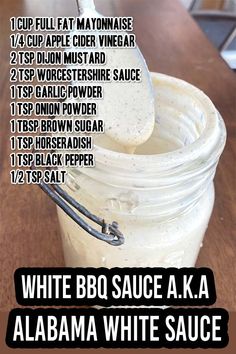 a jar filled with white sauce sitting on top of a wooden table