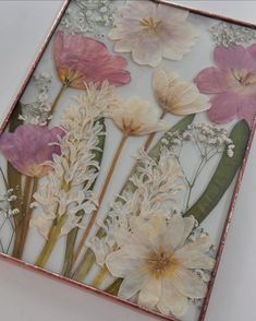 an art piece with pink and white flowers on it's glass paneled frame