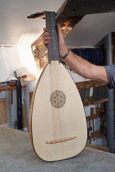 a man is holding an instrument in his right hand and the other hand on top of it