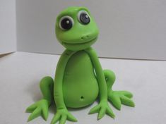 a green frog sitting on top of a white table