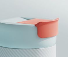 a close up view of the top of a white and blue container with an orange lid