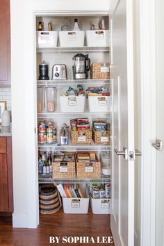 an organized pantry with white bins and baskets