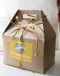 a brown box with a yellow ribbon tied around it and the word welcome is on top