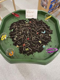 a green tray filled with lots of dirt on top of a table