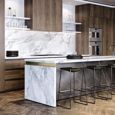 a kitchen with marble counter tops and bar stools