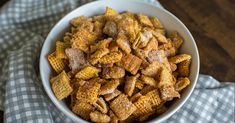 a white bowl filled with cheetos sitting on top of a checkered cloth