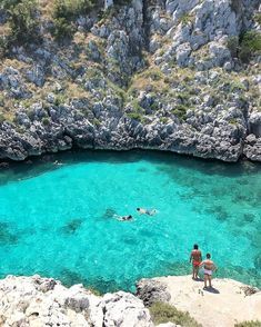 two people are swimming in the clear blue water