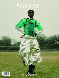 a man standing on top of a green field covered in tin foil next to a soccer ball