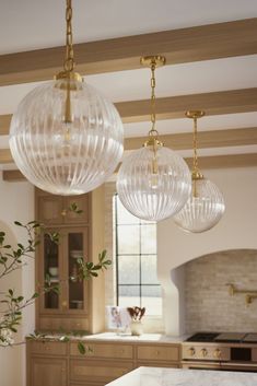 three glass globes hanging from the ceiling in a kitchen