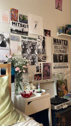 a bedroom with posters and flowers on the wall