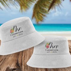 "Celebrate a tropical honeymoon or beach wedding with these colorful floral bucket hats. Each cotton chino twill bucket hat comes with either our Mr. or Mrs. tropical floral design. Customize each hat with a last name and the year they were \"established.\" 𝗣𝗘𝗥𝗦𝗢𝗡𝗔𝗟𝗜𝗭𝗘 𝗜𝗧 Add * The last name (20 characters maximum) * The year the couple was \"established\" (4 digit year) * Character limit includes spaces & punctuation * Personalized text comes in lettering style shown: ALL CAPS * No Honeymoon Beach Hats, Save Water Drink Champagne, Custom Bucket Hats, Tropical Honeymoon, Floral Bucket Hat, Tropical Gifts, Beach Honeymoon, Lettering Style, Beach Hat