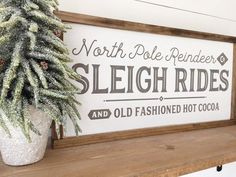 a wooden sign that says north pole reindeer sleigh rides and old fashioned hot cocoa