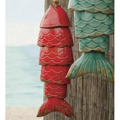 two red and green fish hanging from wooden posts