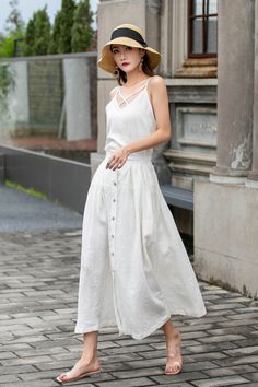 "This white linen midi skirt is perfect for adding a touch of vintage charm to your wardrobe! Featuring a row of buttons down the front and a flattering A-line silhouette, this skirt is both stylish and comfortable. Made from high-quality linen, it's perfect for keeping cool on warm days. Pair with a white blouse or a denim jacket for a chic and versatile look. DETAIL * 100% Linen * Two pockets * Back elastic waist * Button down skirt * Button front skirt * Below Knee Length * A Line skirt, Midi Spring Buttoned Maxi Skirt, Buttoned Maxi Skirt For Spring, Chic Spring Maxi Skirt With Buttons, Spring Maxi Skirt With Buttons For Day Out, Chic Maxi Skirt With Buttons For Spring, Spring Maxi Skirt With Buttons, Knee-length Summer Skirt With Button Closure, Summer Knee-length Skirt With Button Closure, Elegant Relaxed Maxi Skirt With Buttons