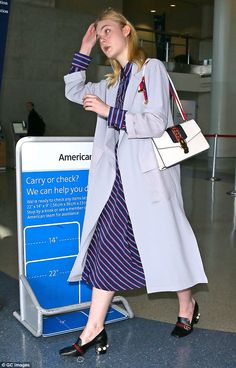 a woman is walking through an airport with her hand on her head