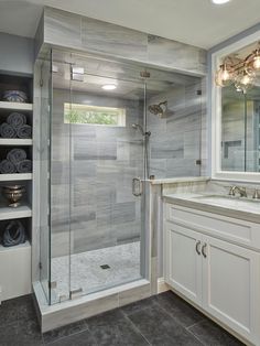 a bathroom with a walk in shower sitting next to a sink and a large mirror