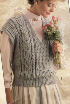 a woman wearing a sweater and holding flowers