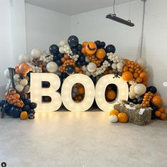 the letters boo spelled out in front of balloons and pumpkins are arranged on top of each other