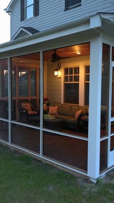 a screened in porch with chairs and couches