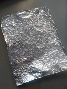 a piece of tin foil sitting on top of a table next to a computer mouse