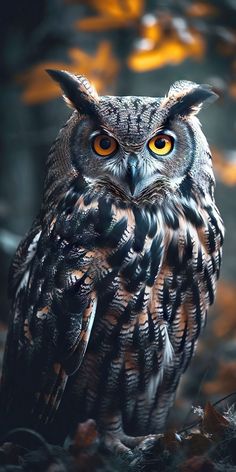 an owl with yellow eyes is sitting in the leaves