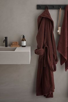 two towels hanging on the wall next to a sink