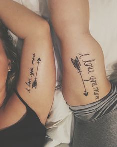 two women with matching tattoos on their arms, one has an arrow and the other says love