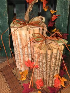 several books are stacked on top of each other with autumn leaves around the book ends