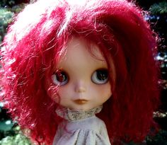 a doll with red hair wearing a white dress